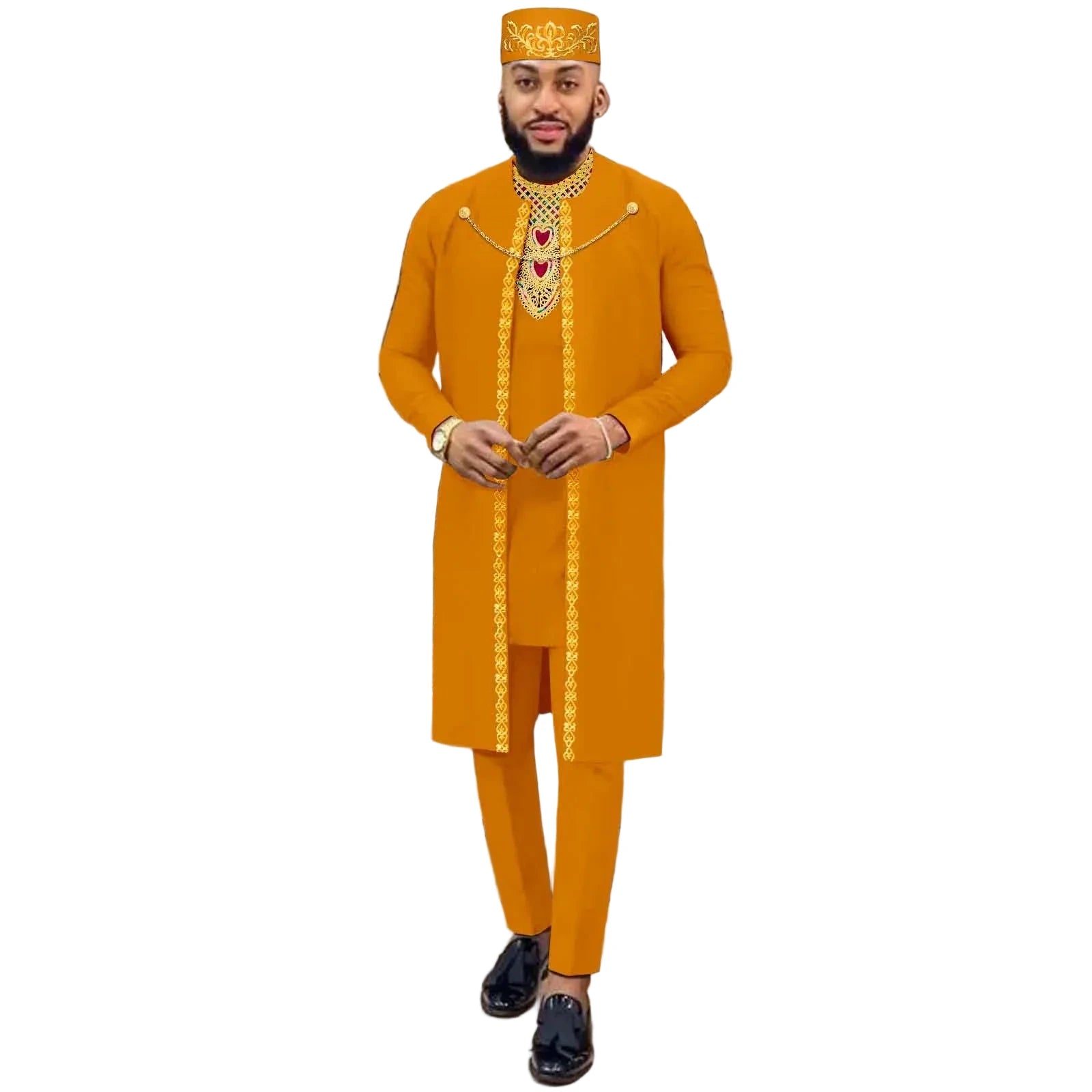 Man wearing an orange traditional outfit with gold embroidery in a decorative setting.